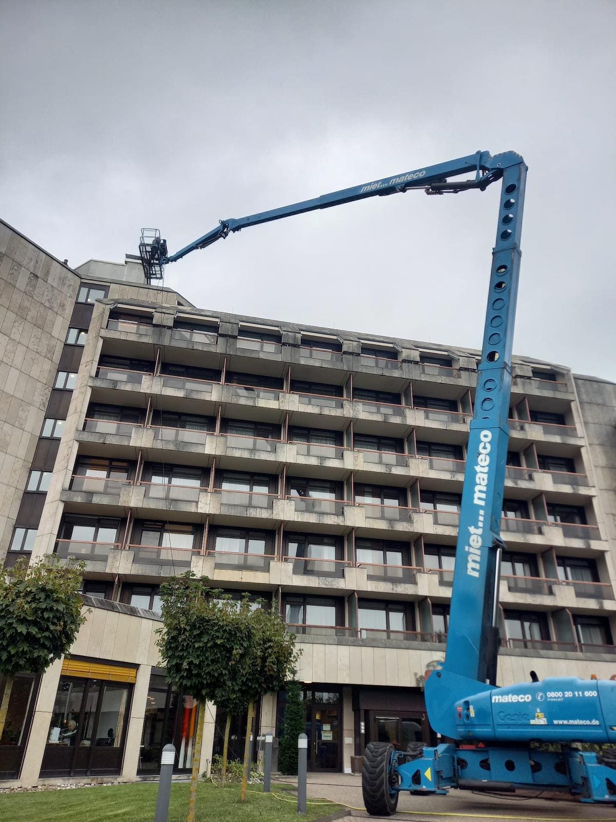 Hubarbeitsbühne reinigt ein Hotelgebäude