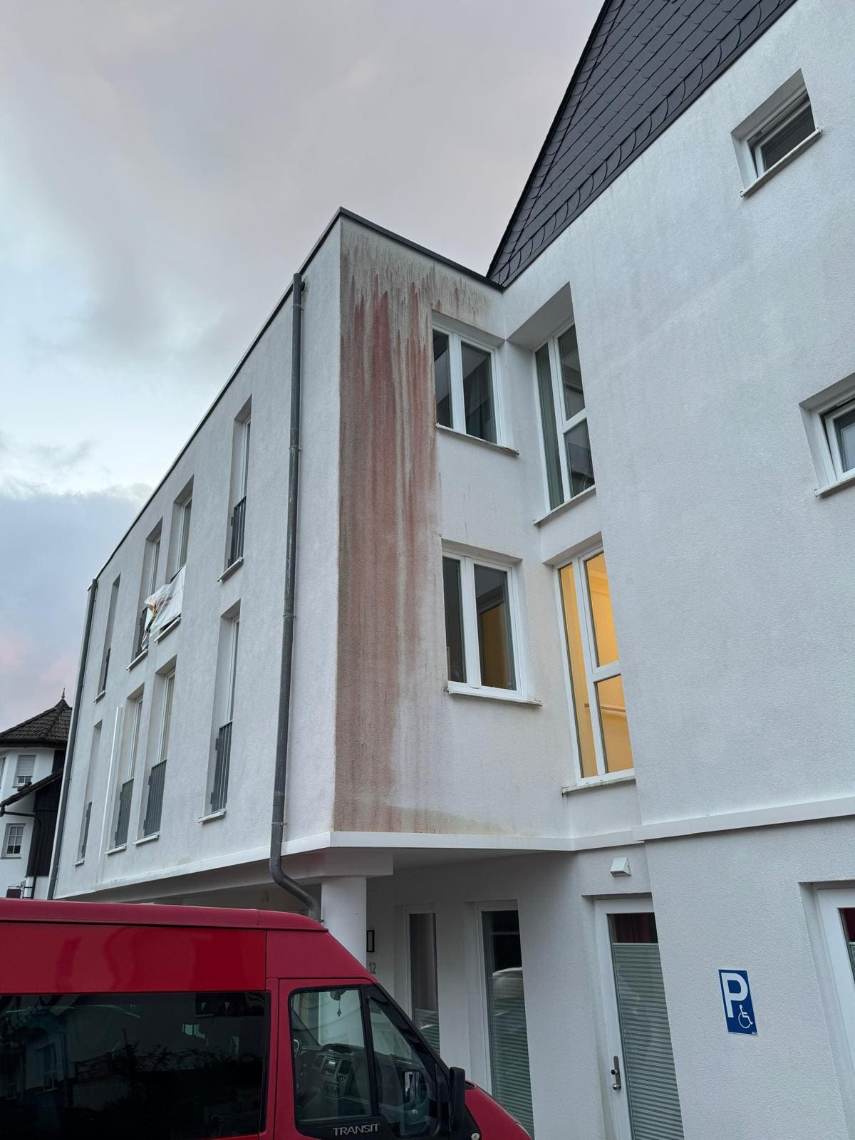 Gebäudeecke vor der Reinigung mit auffälligem rostrotem Verlauf